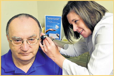 Dr. Lisa B. Fell looking at in a patient's ear at Audiology Experts in Arlington, TX.